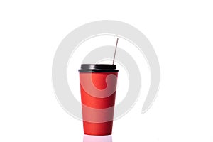 Disposable red cup with paper straw isolated on white background. Coffee to go