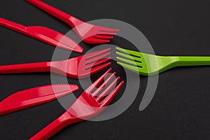 Disposable red and green plastic forks on background
