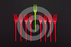 Disposable red and green plastic forks isolated on background