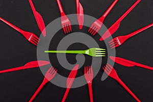 Disposable red and green plastic forks isolated on background