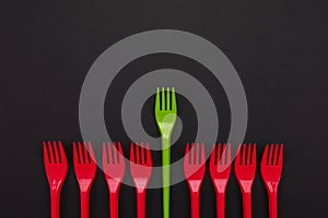 Disposable red and green plastic forks isolated on background