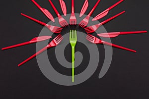 Disposable red and green plastic forks isolated on background