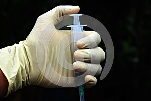 Disposable syringe on the gloves hand