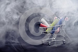 Disposable vapes in a shopping cart on a black background. Modern electronic cigarettes. photo