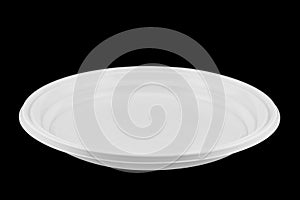 Disposable white plastic plate isolated on black background