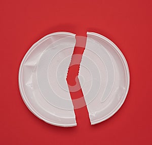 Disposable white plastic plate on a red background