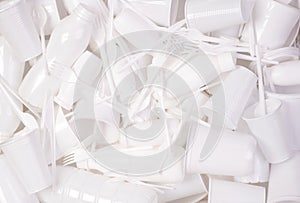 Disposable white single use plastic objects such as bottles, cups, forks and spoons