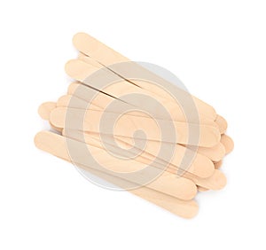 Disposable wooden spatulas for depilatory wax on white background, top view