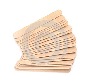 Disposable wooden spatulas for depilatory wax on white background, top view