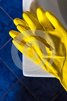 Disposable yellow rubber gloves for cleaning the bath, cleaning the household using the rubber gloves to protect hands - Image