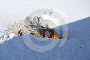 Disposal of trash through burning trash in the snow. A place for incineration of household waste in the garden. Bonfire in a