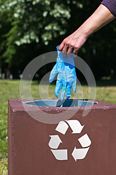 disposing of protective glove in recycle bin