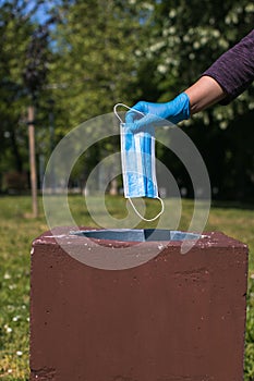 disposing of protective mask in public park bin