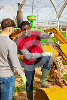 Disquieted african american gardener talking to friend