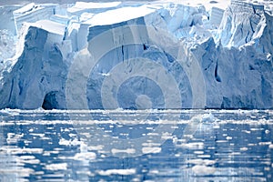 Disruptling glacier wall in Antarctica, majestic blue and white ice wall with gate in front.