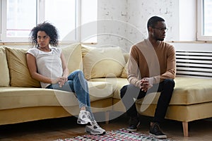 Dissatisfied American couple sitting apart having relations problems