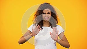 Dissatisfied biracial female crossing hands, showing no gesture to camera, ban