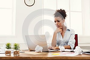 Dissatisfied business woman working on laptop at office