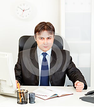 Dissatisfied businessman banging fist on table photo