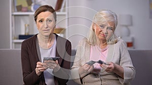 Dissatisfied elderly women showing euros banknotes at camera, low incomes