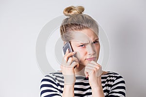 Dissatisfied frustrated young business woman talking on a smartphone. Unsuccessful negotiations, bad news, conversations, bad mood