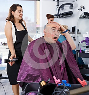 Dissatisfied male client in hair salon