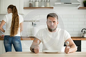 Dissatisfied man waiting for dinner cooked by wife