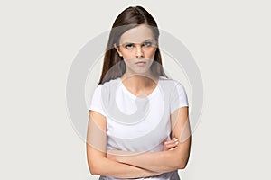 Dissatisfied millennial woman looking at camera posing on grey background