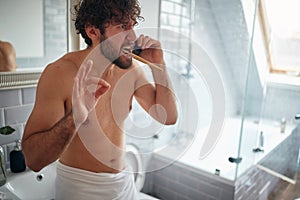 Dissatisfied topless man fighting while brushing