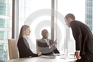 Businessman arguing with multi-ethnic partners photo