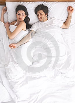 Dissatisfied woman can`t sleep with her husband who stretched arms