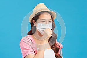 Dissatisfied woman in hat protects face with mask, thinks abot risk of epidemic disease, has virus infection