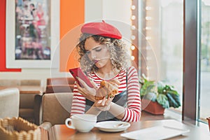 Dissatisfied woman using smartphone in european city street cafe. Failed date