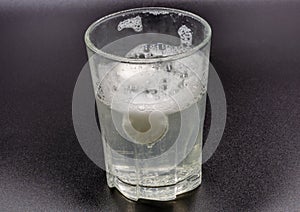Dissolving instant effervescent tablets in a glass of water closeup