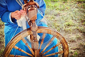 Distaff creates a thread from a spindle. Hand spinning wheel in nature, close-up