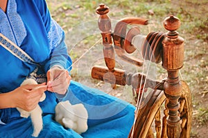 Distaff creates a thread from a spindle. Manual spinning wheel outdoors, lifestyle