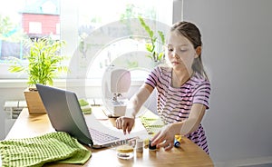 Distance education concept. Covid lockdown. Caucasian preteen girl learns to sew online during self-isolation