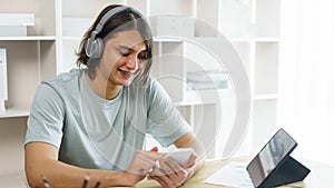 Distance education concept, Teen boy in headphone to listen music and use phone after study online