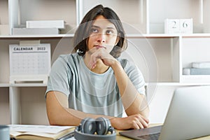 Distance education concept, Teen boy sitting to contemplate while listening lecture online at home