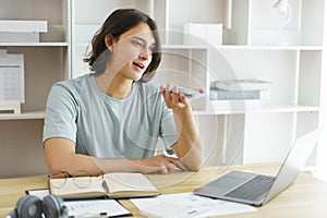 Distance education concept, Teen boy talking on phone and using laptop to lesson class online