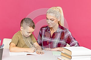 Distance homework with mother at home at quarantine time. Boy with mom sitting at the desk and studying.