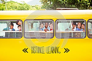 Distance learning against cute pupils smiling at camera in the school bus