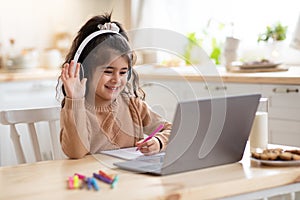 Distance Learning. Cute little home schooler girl having video lesson with laptop