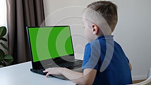 Distance learning online education. Cute caucasian boy doing homework on a computer while quarantine epidemia corona