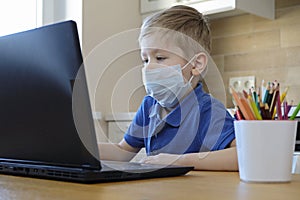 Distance learning online education. Cute caucasian boy doing homework at home while quarantine of epidemia corona virus