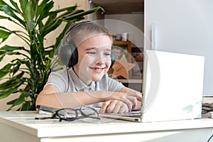 Distance learning online education. A schoolboy is studying at a computer at home and doing school homework. quarantine