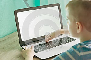 Distance learning online education. Schoolboy studying at home with laptop and doing school homework