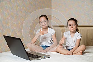 Distance learning online education. Schoolgirl and her sister studying at home with digital tablet laptop notebook