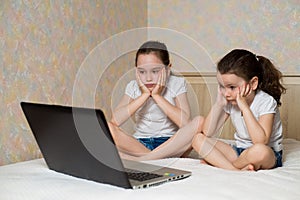 Distance learning online education. Schoolgirl and her sister studying at home with digital tablet laptop notebook