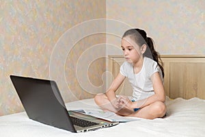 Distance learning online education. Schoolgirl studying at home with digital tablet laptop notebook